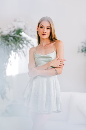 Tiffany Tatum in silk dress posing on white couch with tattoos photo 3