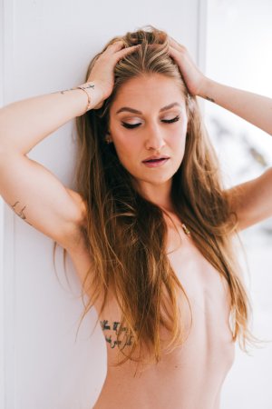Tiffany Tatum in silk dress posing on white couch with tattoos photo 14