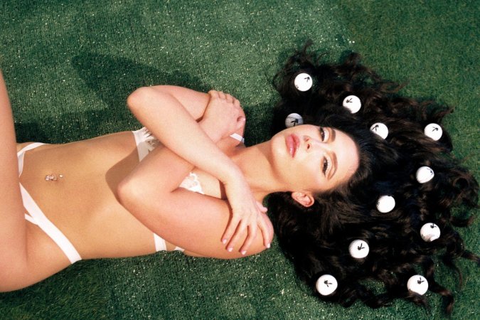 Jane Wilde posings with pink golf club on green grass photo 6