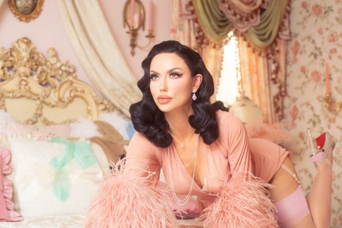 Bryona Ashly poses in pink feather robe on white bedding photo 3