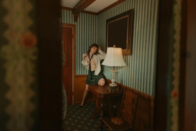 Ivy Rose in schoolgirl skirt poses topless in bedroom with mirror and lamp photo 4